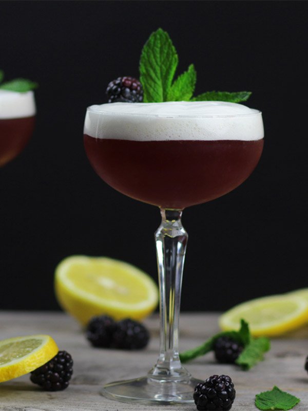 A blueberry mint burbon cocktail made with cocktail foam